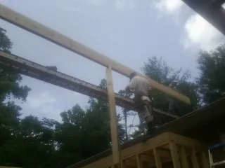 Carpenter setting a ridge beam over a new addition frame — Ice Dam Removal by Roofing Brothers in Maugansville