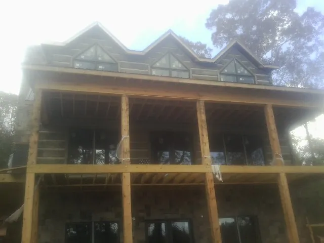 Dormers and porch framing on a large log home under construction — Roof Coating work by our crew in Maugansville