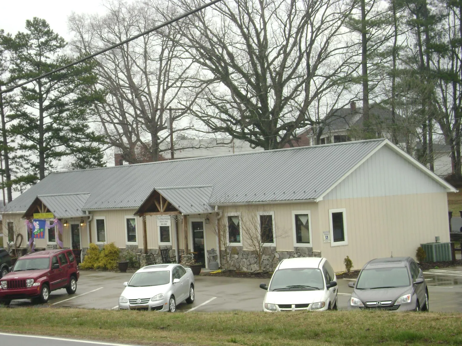 Gray metal roof with timber entry brackets on a small commercial building in Maugansville